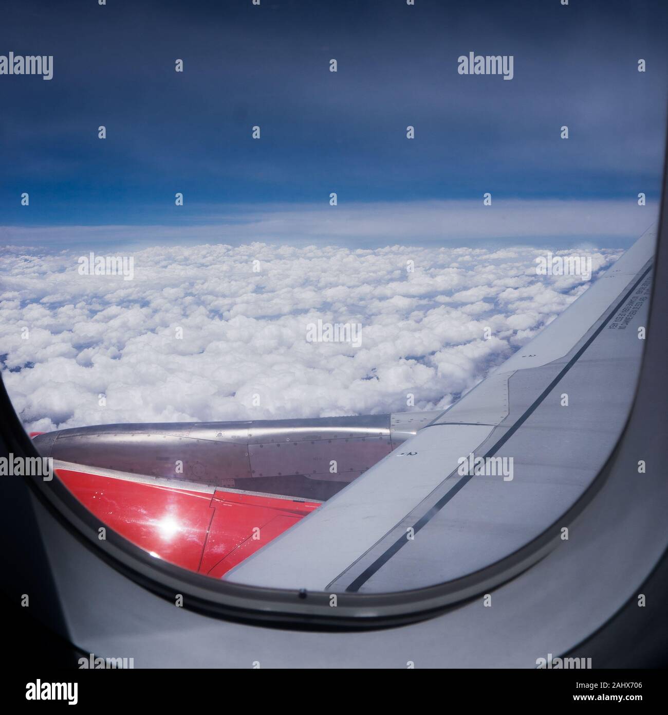 La fenêtre de l'avion avec fluffy clouds Banque D'Images