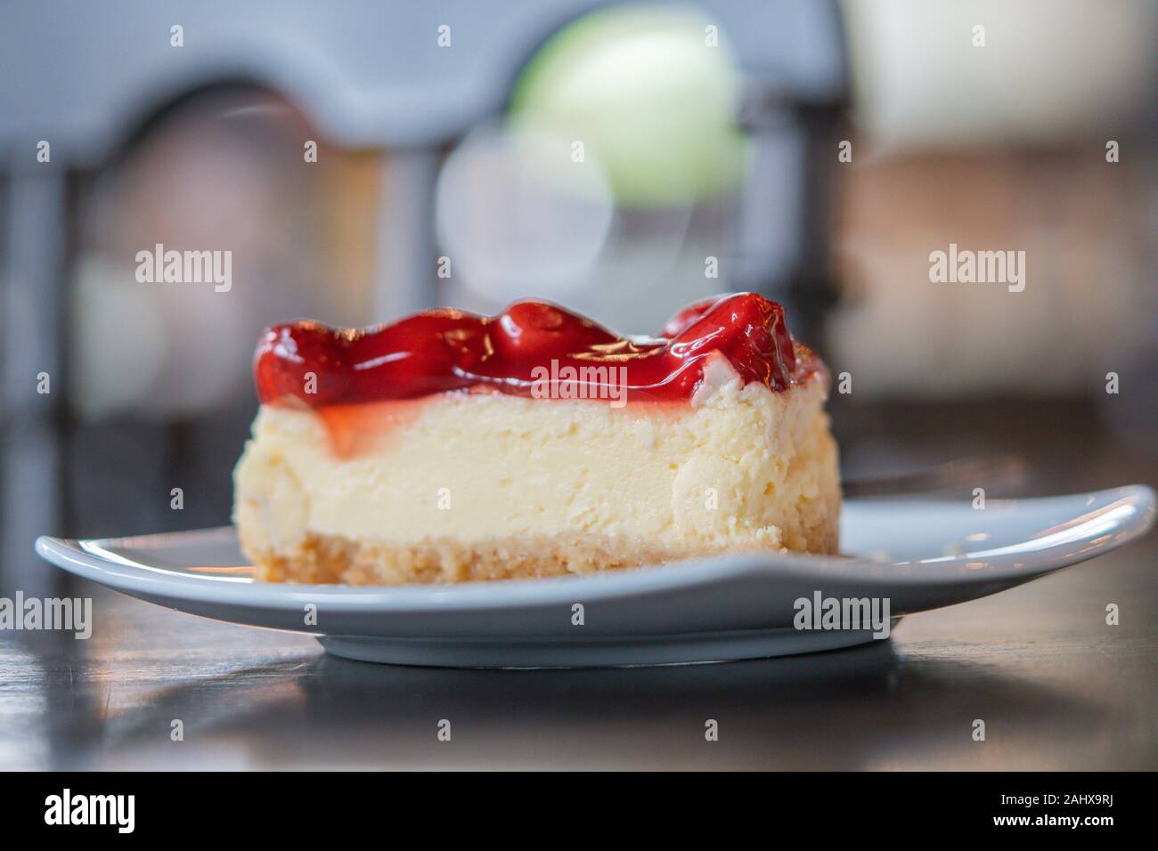 Libre de morceau de gâteau aux fraises avec de la crème fouettée servir sur une assiette blanche, douce et sélective d'arrière-plan flou artistique Banque D'Images