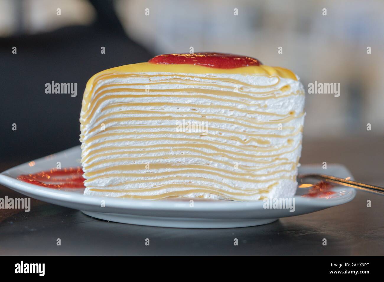 Libre de morceau de gâteau aux fraises avec de la crème fouettée servir sur une assiette blanche, douce et sélective d'arrière-plan flou artistique Banque D'Images