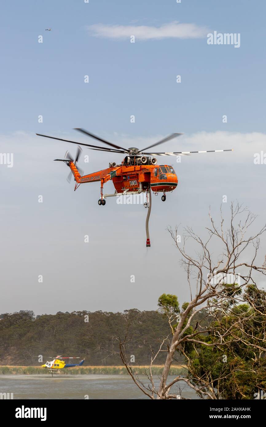 Erickson Air Crane hélicoptère décoller après le remplissage avec une charge d'eau pour combattre un incendie. Banque D'Images