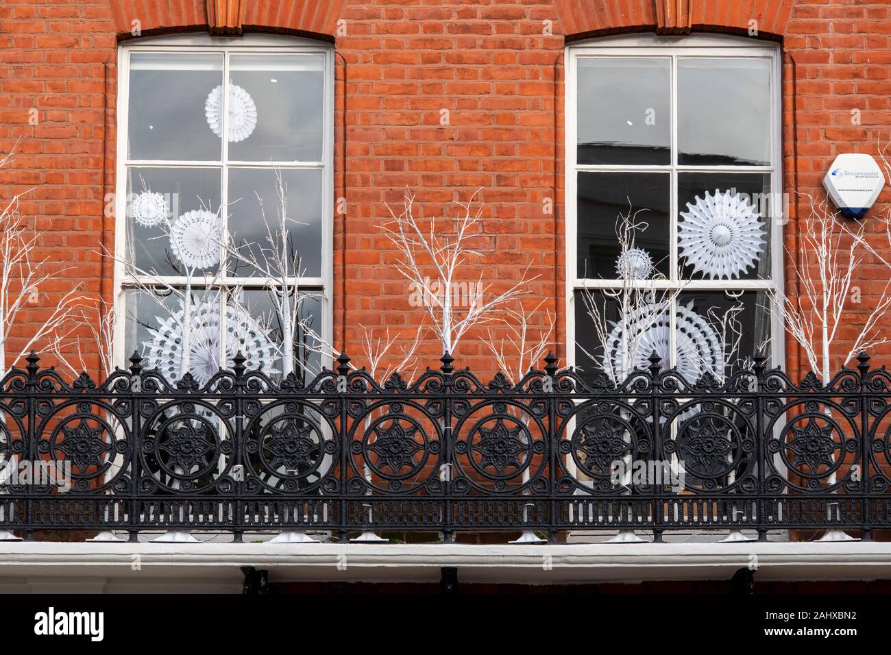 Décorations de Noël flocon de papier dans une fenêtre de la chambre. Chelsea, Londres, Angleterre Banque D'Images