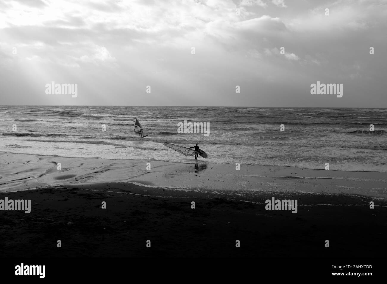 Les véliplanchistes au Brook beach Compton Bay à l'hiver dans l'Ouest Wight sur l'île de Wight Banque D'Images