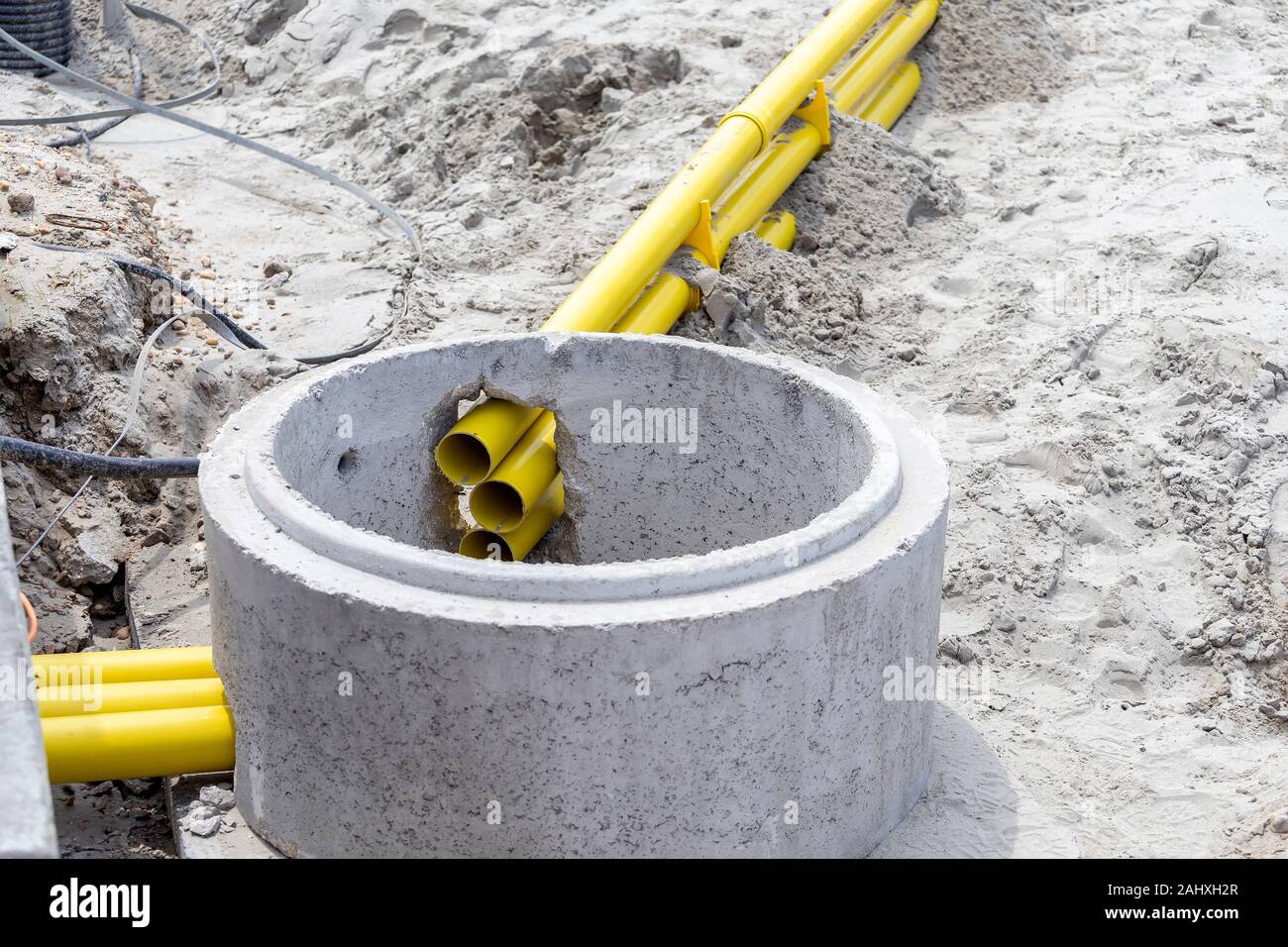 Tranchée avec le jaune pour les conduits de câble. Pose de câbles