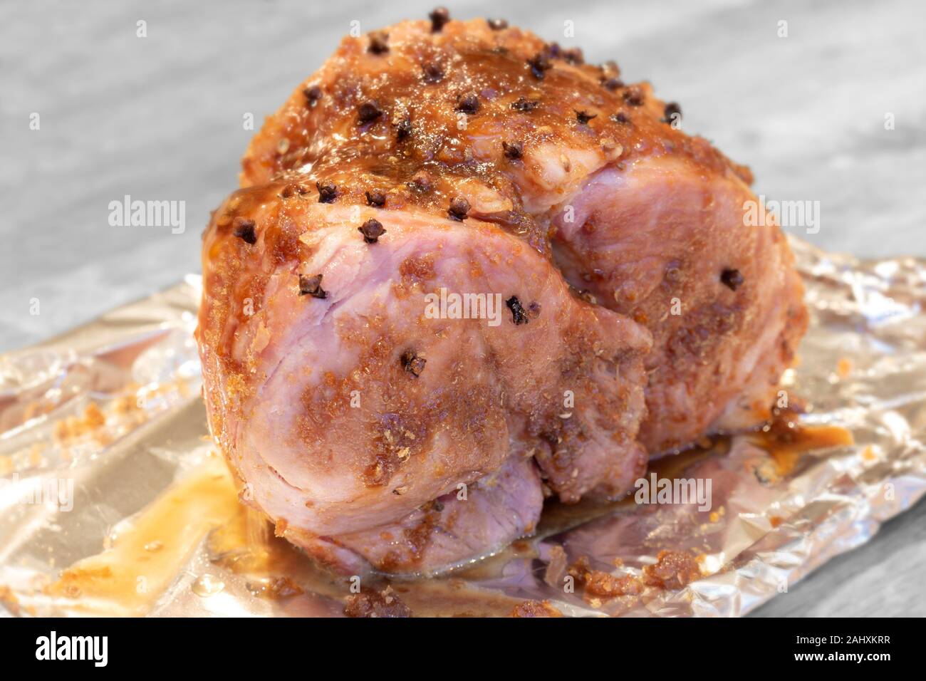 Jambon à cuire avec le clou de girofle et au miel glacé prêt à rôtir. Sur un fond de bois Banque D'Images