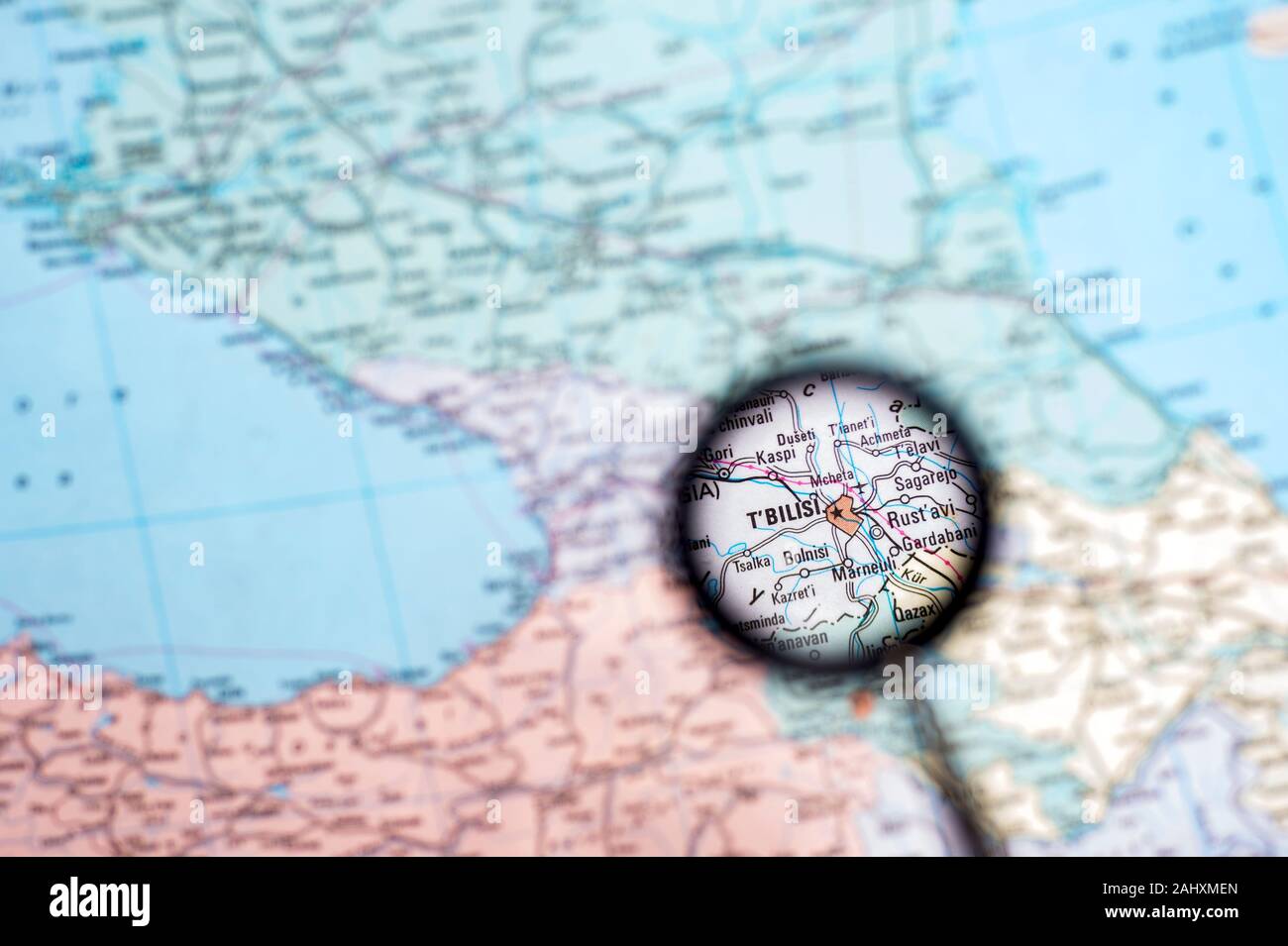 La Géorgie avec le capital de Tbilissi close-up à travers une loupe sur l'arrière-plan d'une carte géographique floue. Banque D'Images