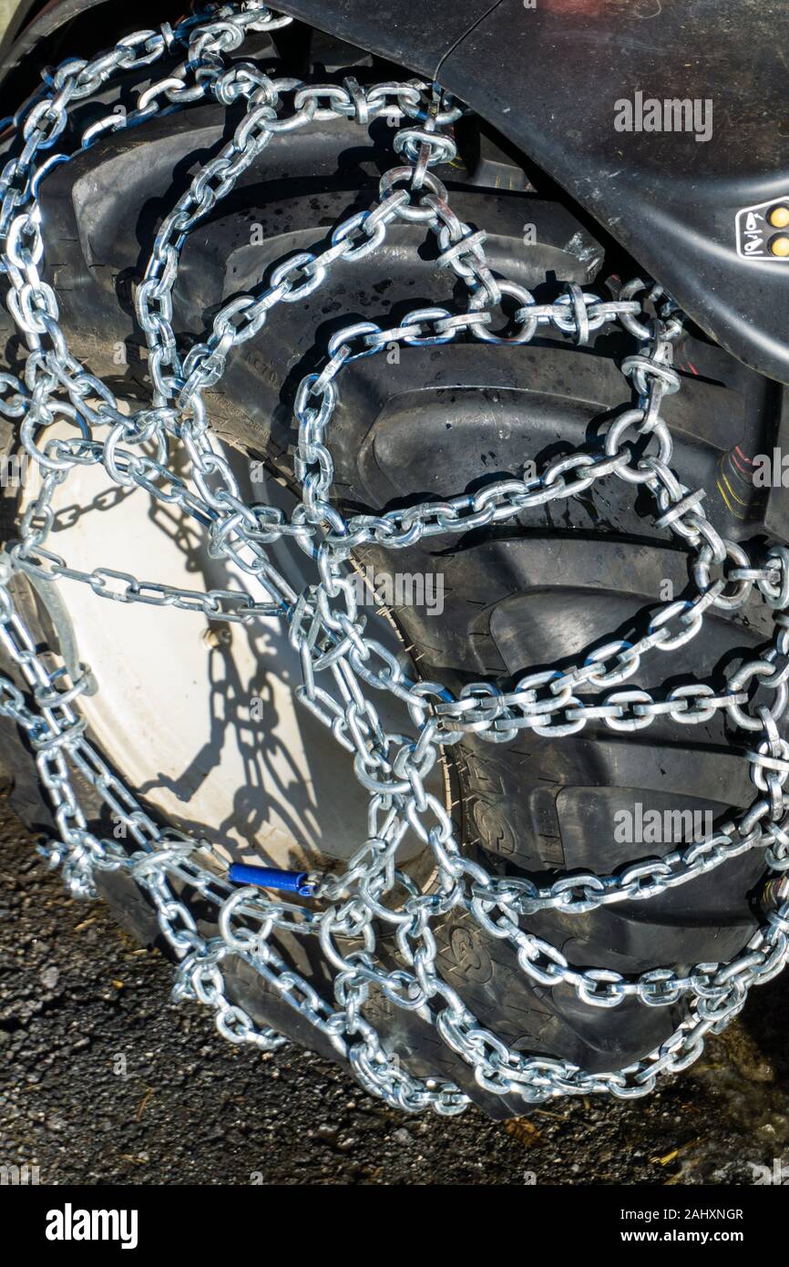 Une vue rapprochée des chaînes à neige sur la montagne de pneus petit tracteur en hiver Banque D'Images