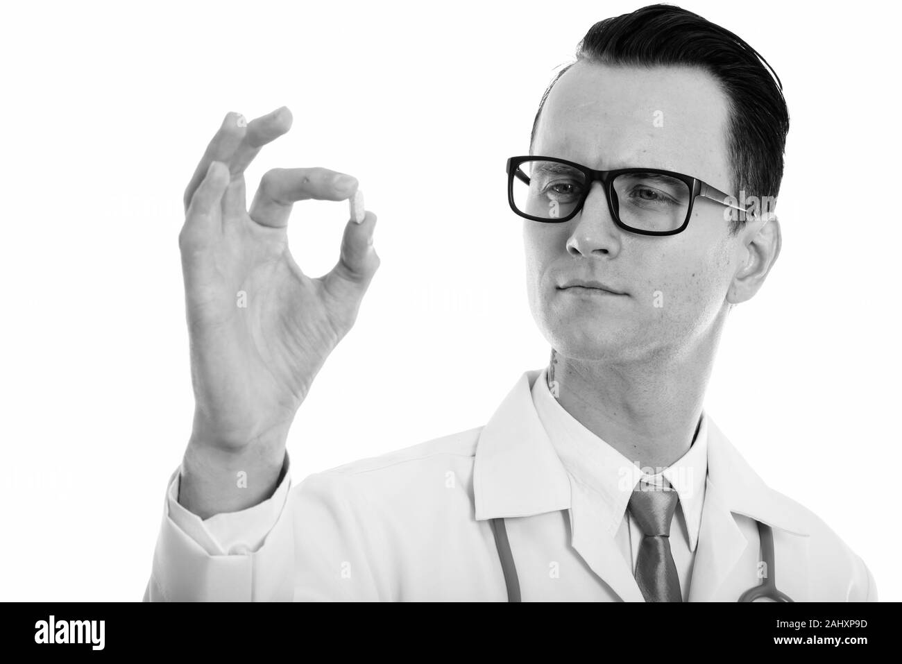 Portrait de jeune homme séduisant médecin examinant la vitamine tablet Banque D'Images