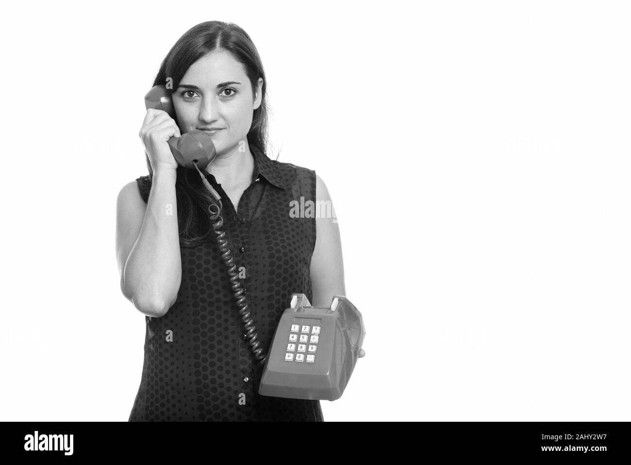 Studio shot of woman talking on old telephone Banque D'Images