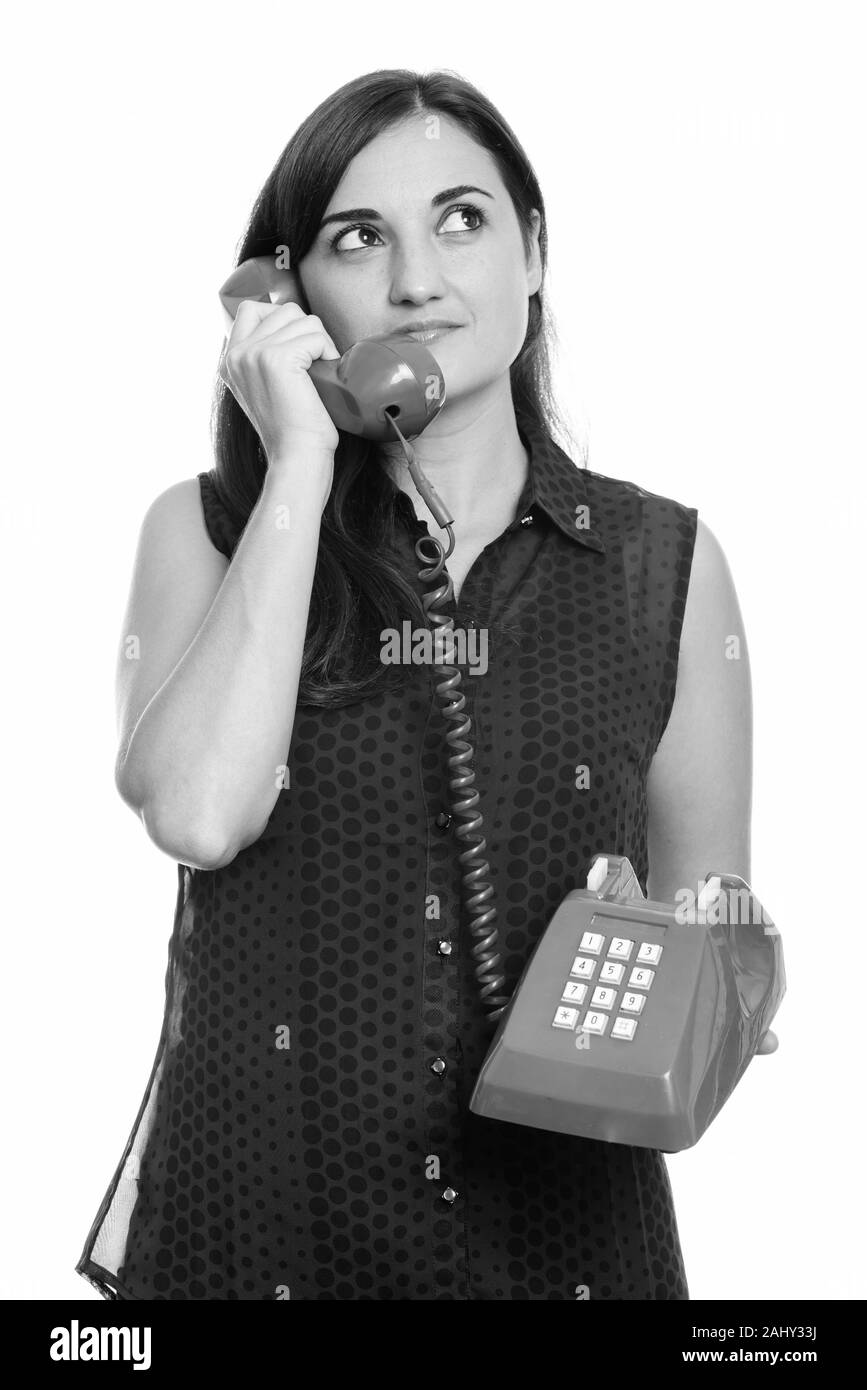 Studio shot of woman talking on vieux téléphone en pensant Banque D'Images