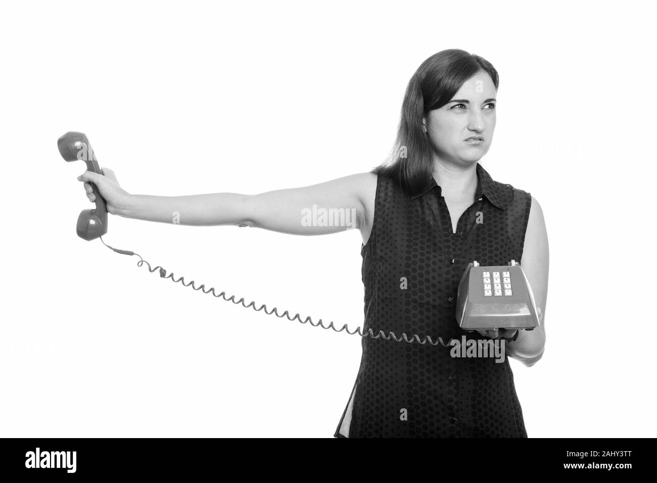 Studio shot of woman holding dégoûté vieux téléphone Banque D'Images