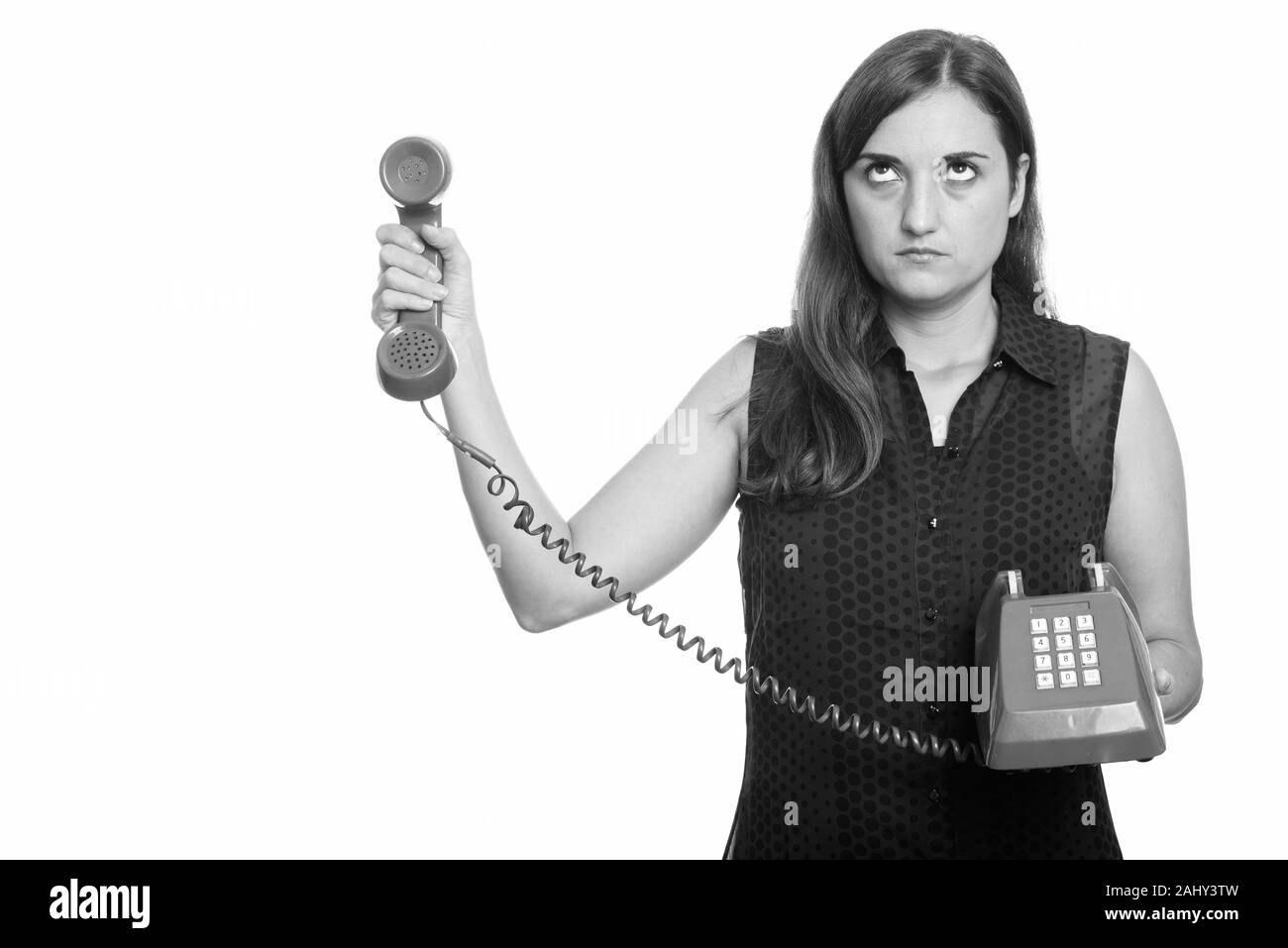Studio shot of woman holding old telephone Banque D'Images
