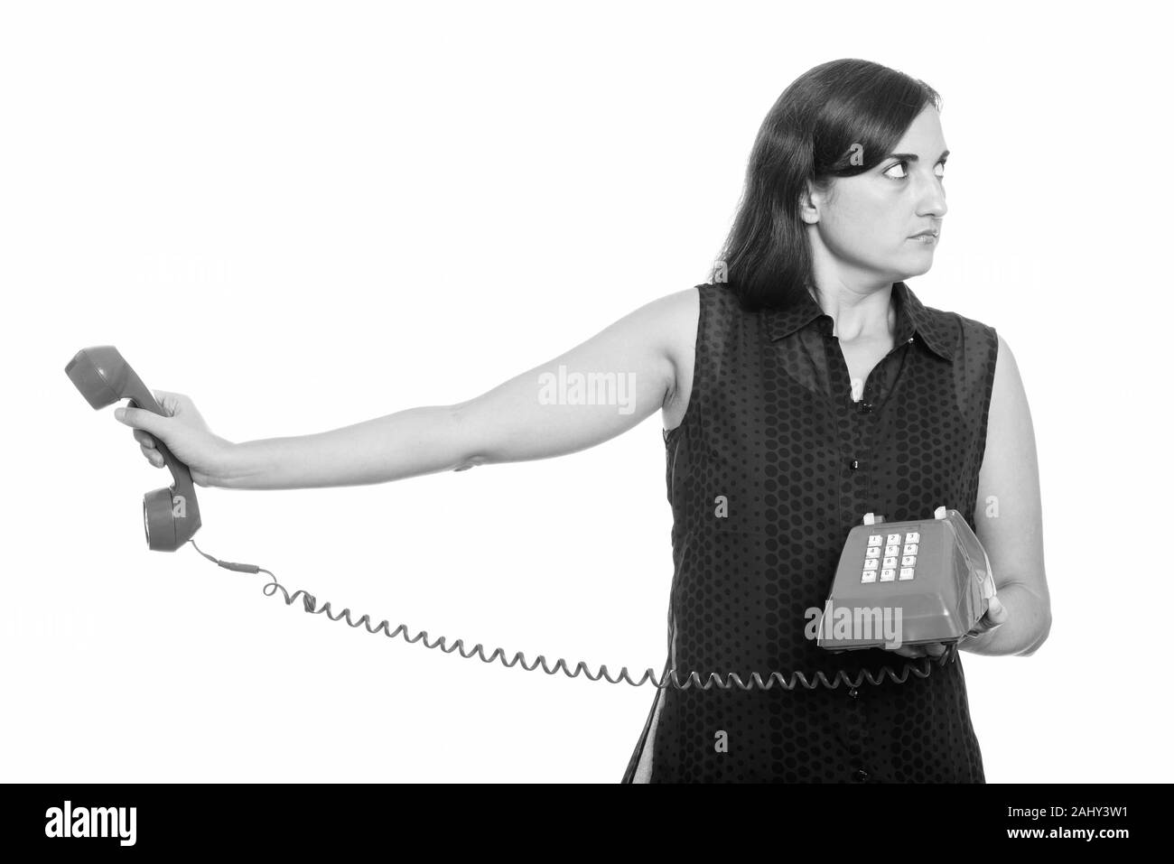 Studio shot of woman holding ennuyé vieux téléphone Banque D'Images