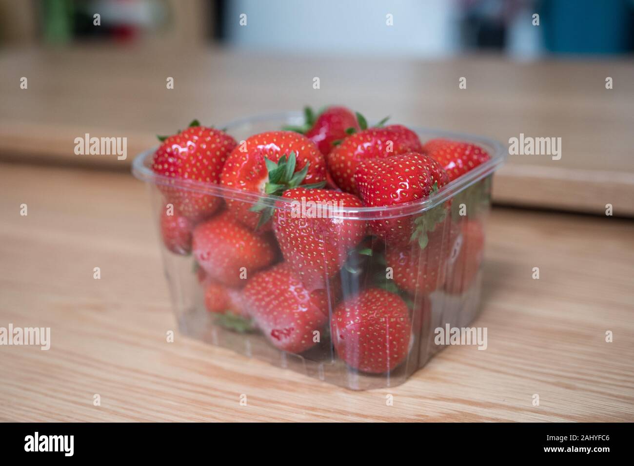Barquettes en plastique des fraises sur une table en bois. Gros plan et arrière-plan flou. De délicieux fruits rouges frais. Pas éco-friendly. Le recyclage à faire. Banque D'Images Barquettes en plastique des fraises sur une table en bois. Gros plan et arrière-plan flou. De délicieux fruits rouges frais. Pas éco-friendly. Le recyclage à faire. Banque D'Images