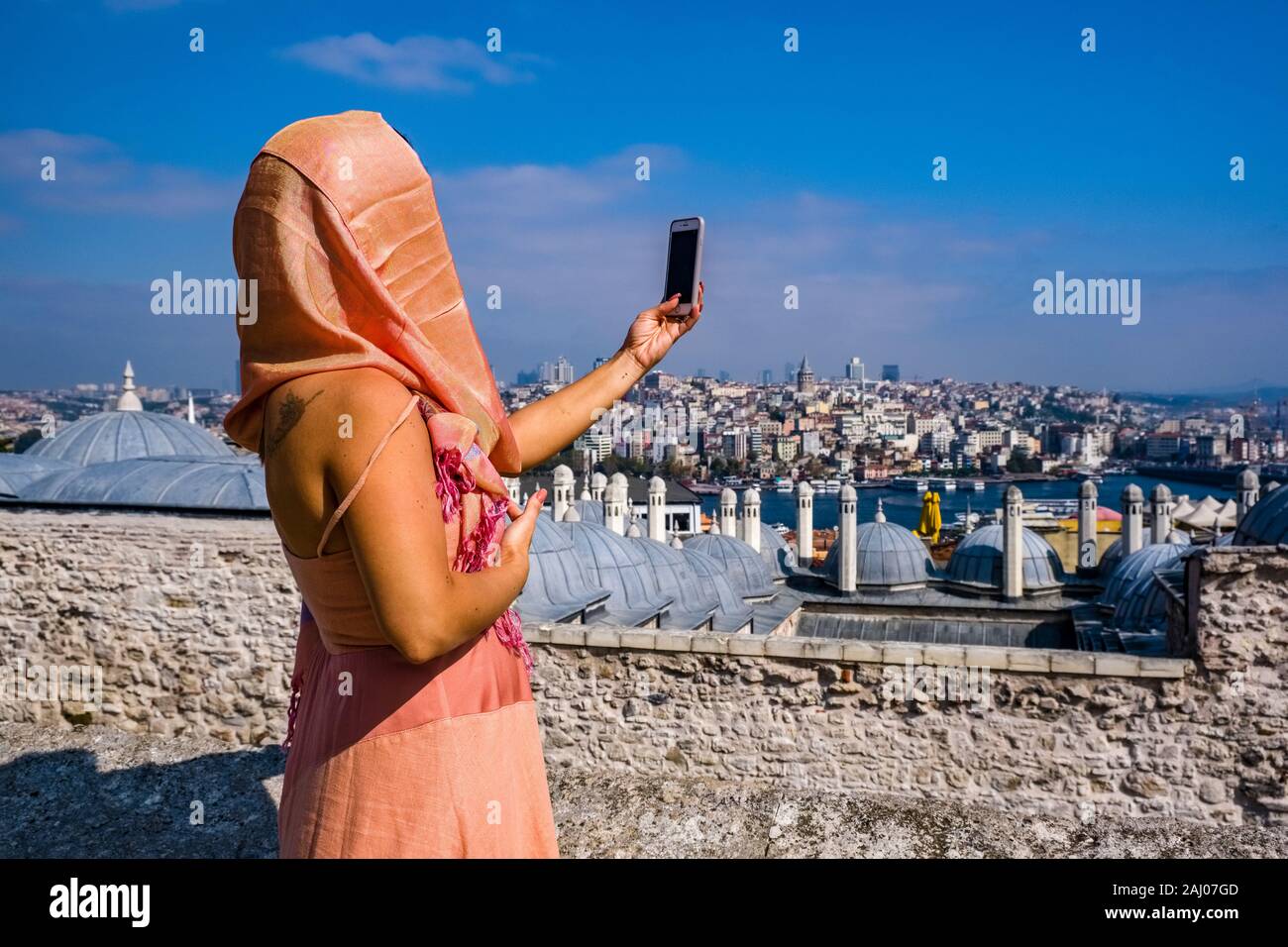 Une femme prend un à selfies Süleymaniye Camii, la Mosquée Süleymaniye, le quartier Karaköy avec la tour de Galata, Galata Kulesi, dans la distance Banque D'Images