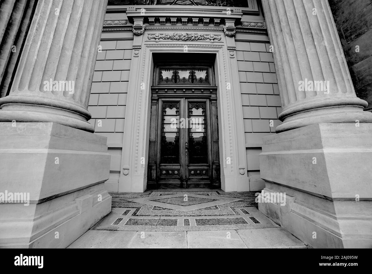 Ancienne et belle massives colonnes romaines avec porte en bois grand angle photographie d'architecture. Photo en noir et blanc Banque D'Images