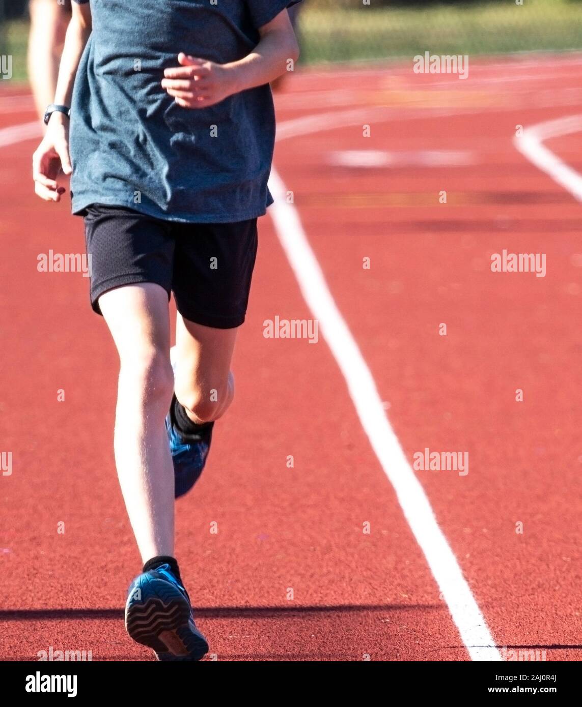 Portrait d'un coureur à l'appareil photo sur une piste rouge à lane. Banque D'Images