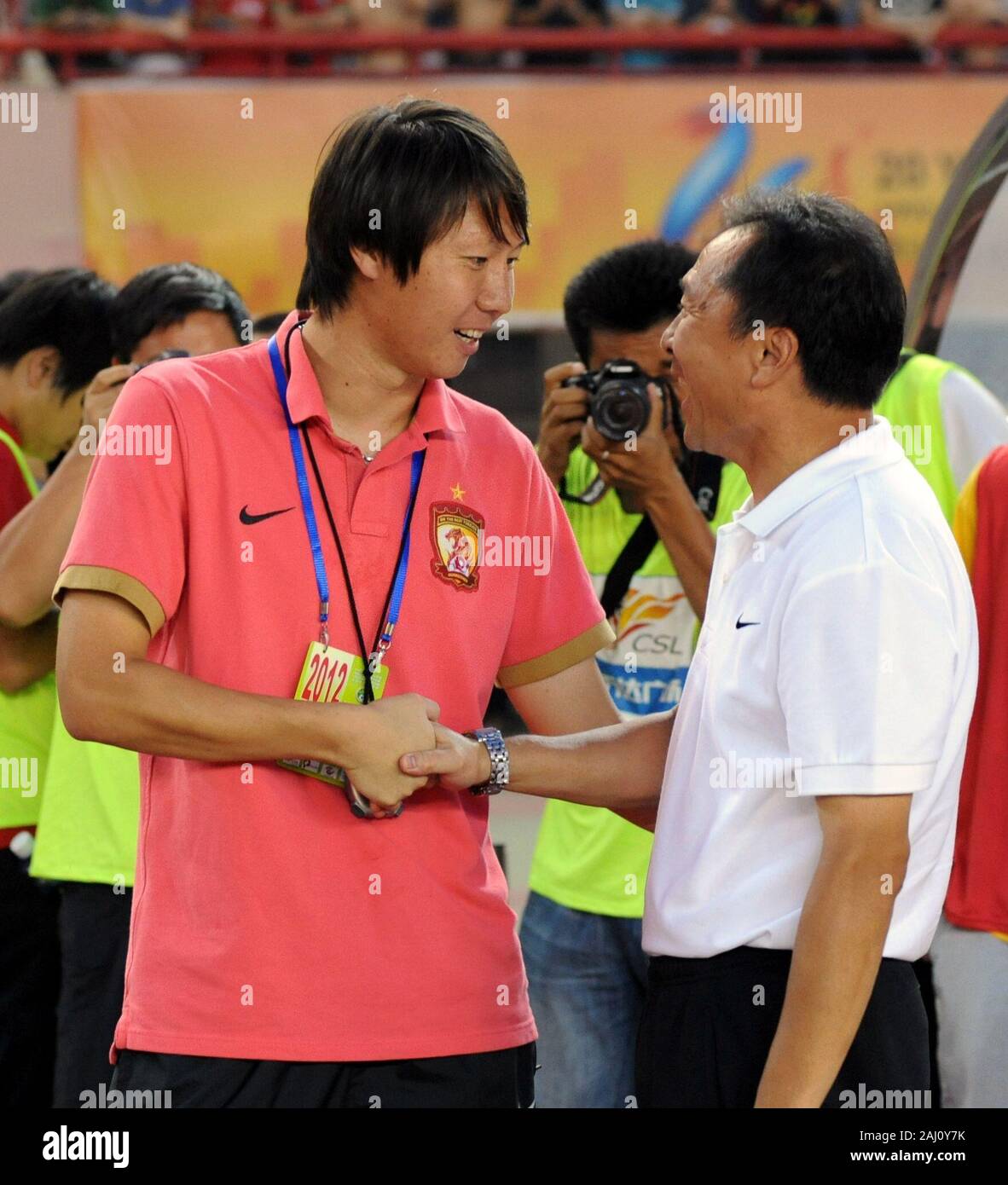 Beijing, Chine. 21 juillet, 2012. Photo prise le 21 juillet 2012 montre coach Fitness Li Tie (L) de Guangzhou Evergrande, serre la main avec Shen Wuyi Avenue, entraîneur-chef de Henan Jianye football club avant de la Chinese Super League Football Association à Zhengzhou, province du Henan en Chine centrale. La Chinese Football Association (CFA) a nommé 42 ans Li Tie comme entraîneur-chef de l'équipe nationale du pays sur une base permanente. Crédit : Li Bo/Xinhua/Alamy Live News Banque D'Images