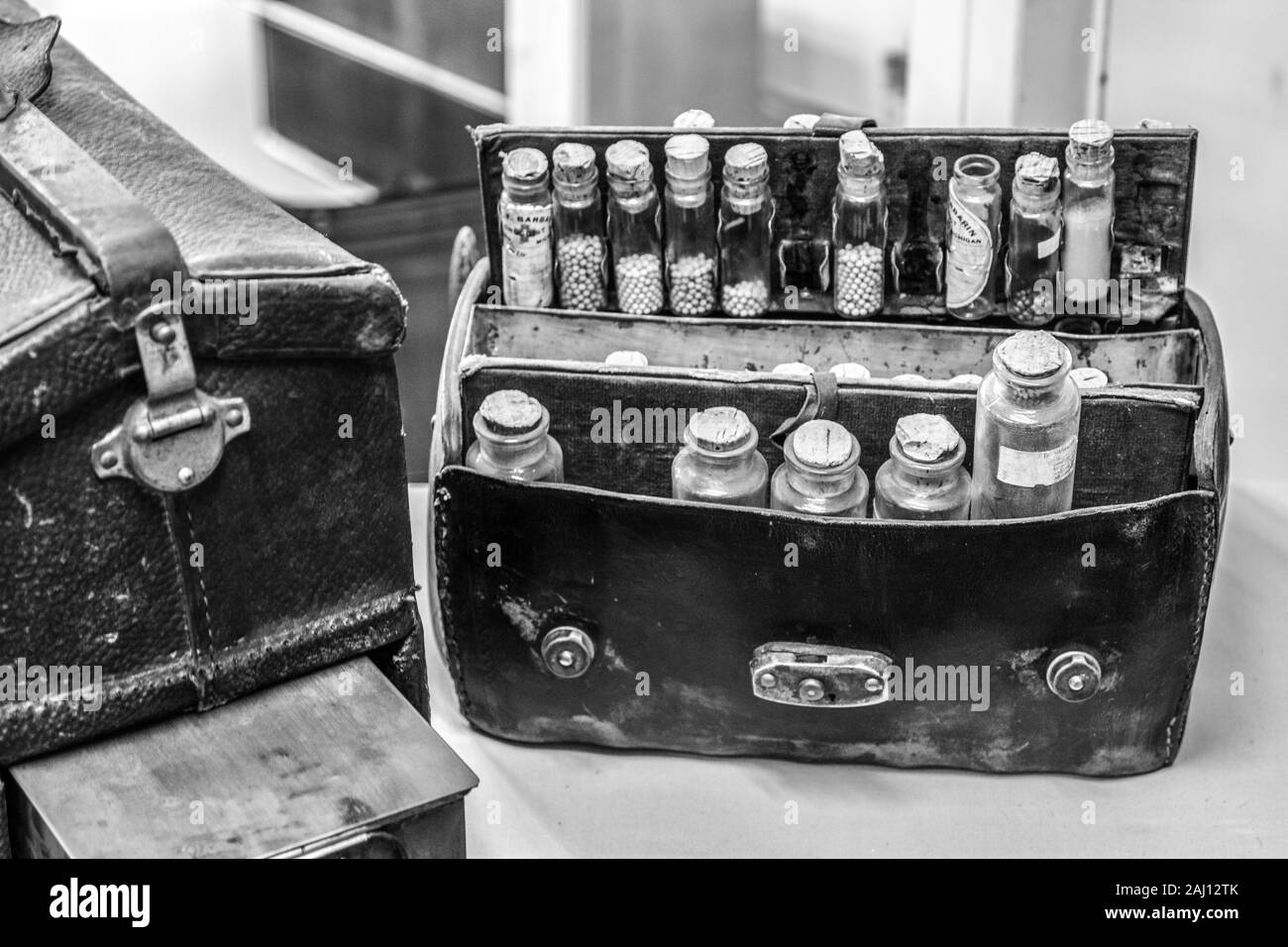 Vintage sac de médecine. Médecin en cuir noir et blanc sac avec plusieurs bouteilles en verre d'herbes, teintures, et remède à la maison. Banque D'Images