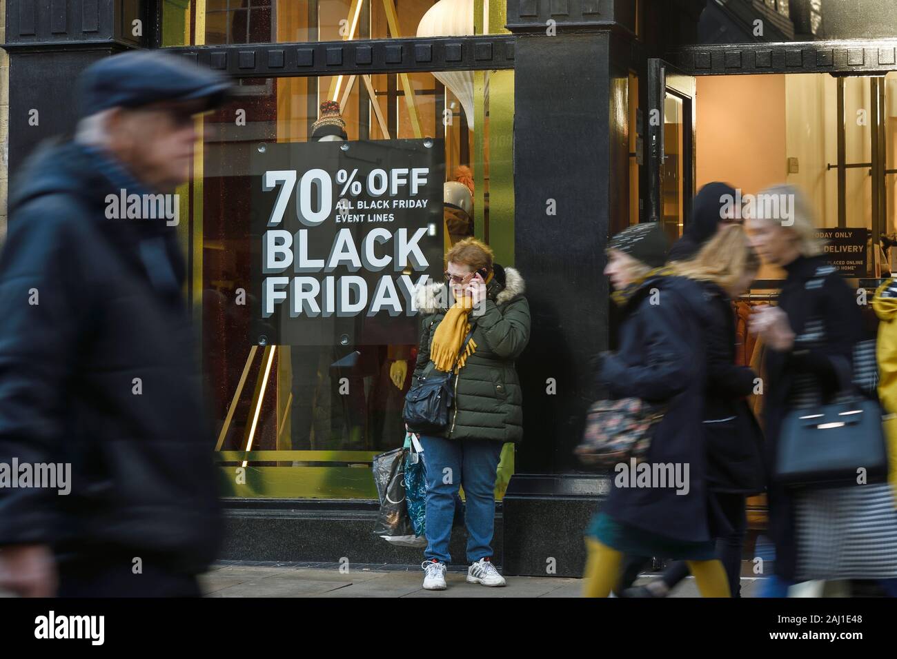 En passant devant les acheteurs panneaux pour le Black Friday Ventes en centre-ville de Chester UK Banque D'Images