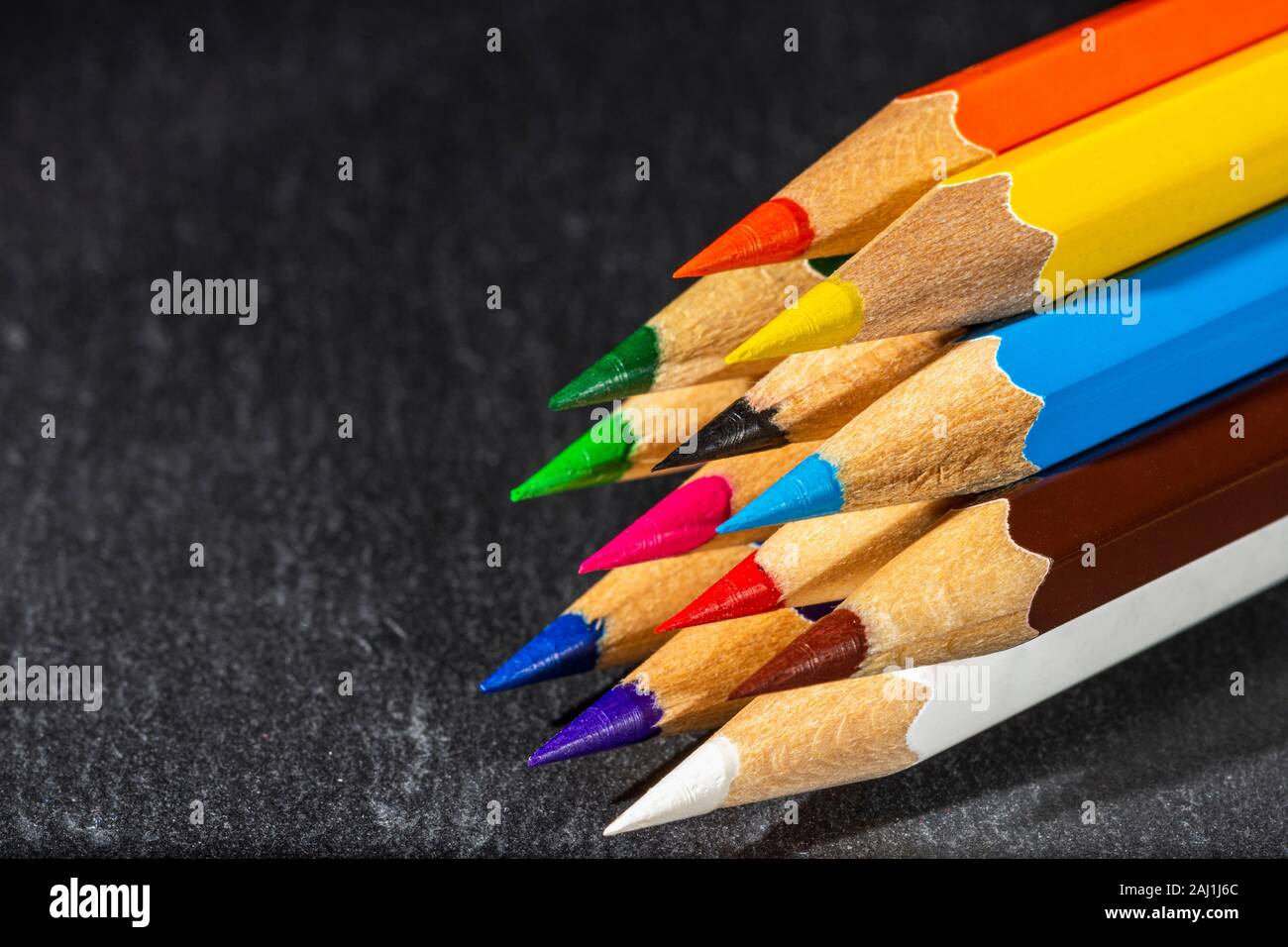 Crayons de couleur sur fond noir, le retour à l'école contexte concept avec des crayons de couleurs et de copie du texte pour l'espace Banque D'Images
