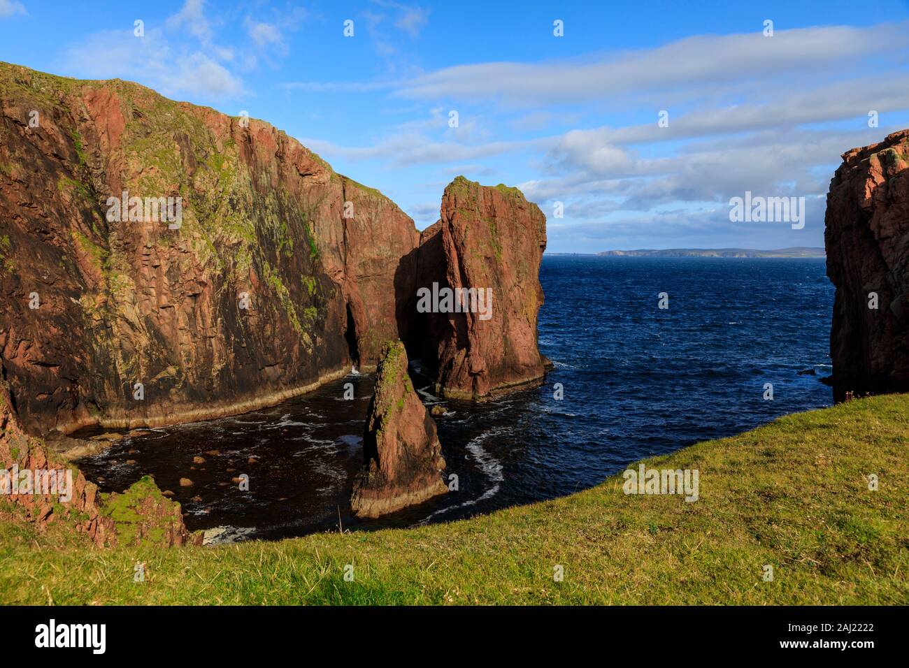 Jambon du nord, couvertes de lichen d'immenses falaises de granit rouge et de piles, Muckle Roe Island, îles Shetland, Écosse, Royaume-Uni, Europe Banque D'Images