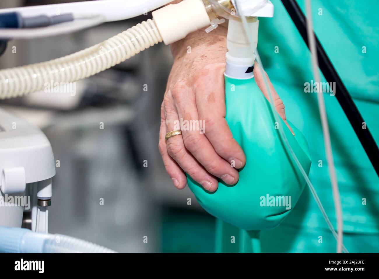 Close up d'un médecin part en appuyant sur le sac de réaspiration d'anesthésie chirurgicale alors que leur équipe se prépare pour la chirurgie des patients Banque D'Images