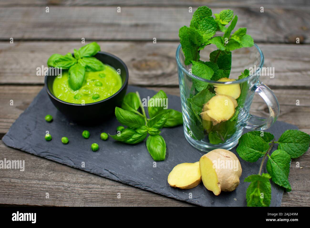 Tasse vide avec de la menthe et le gingembre en tranches. En outre, une délicieuse crème de pois au basilic Banque D'Images Tasse vide avec de la menthe et le gingembre en tranches. En outre, une délicieuse crème de pois au basilic Banque D'Images