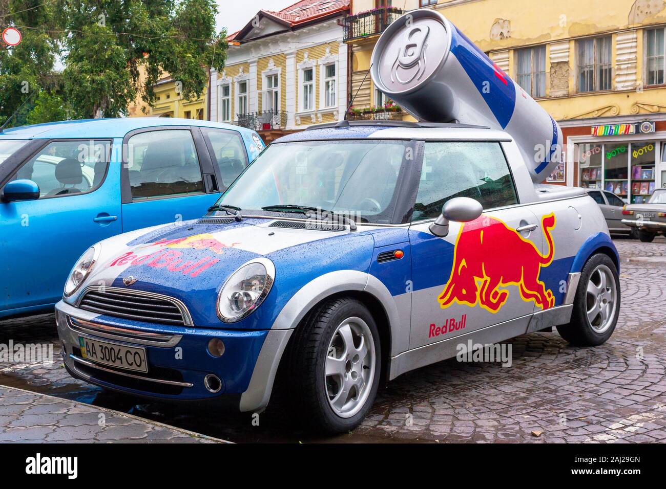 Uzhhorod, Ukraine - 14 août, 2013 : Red Bull Mini cooper voiture publicitaire avec un bidon de boisson énergétique derrière. plaqués car tuning utilisé pour la promotion. wet adver Banque D'Images