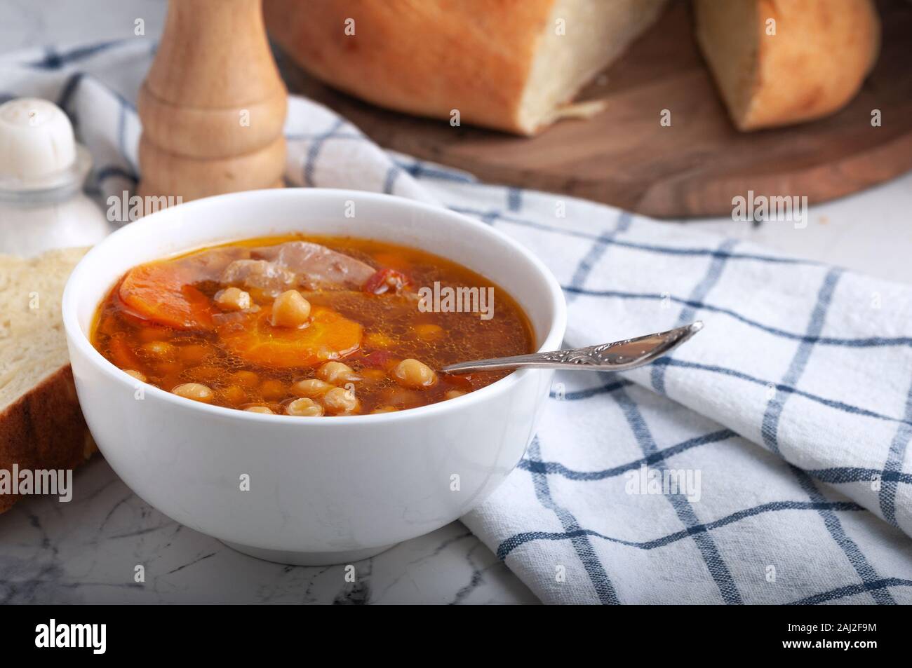 Soupe au poulet, petits pois, tomates et carottes en rondelles. Savoureuse soupe chaude. Banque D'Images