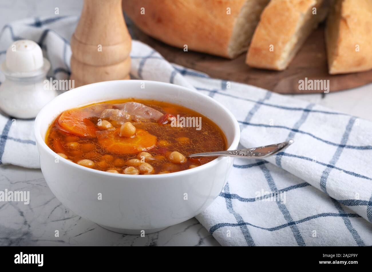 Soupe au poulet, petits pois, tomates et carottes en rondelles. Savoureuse soupe chaude. Banque D'Images