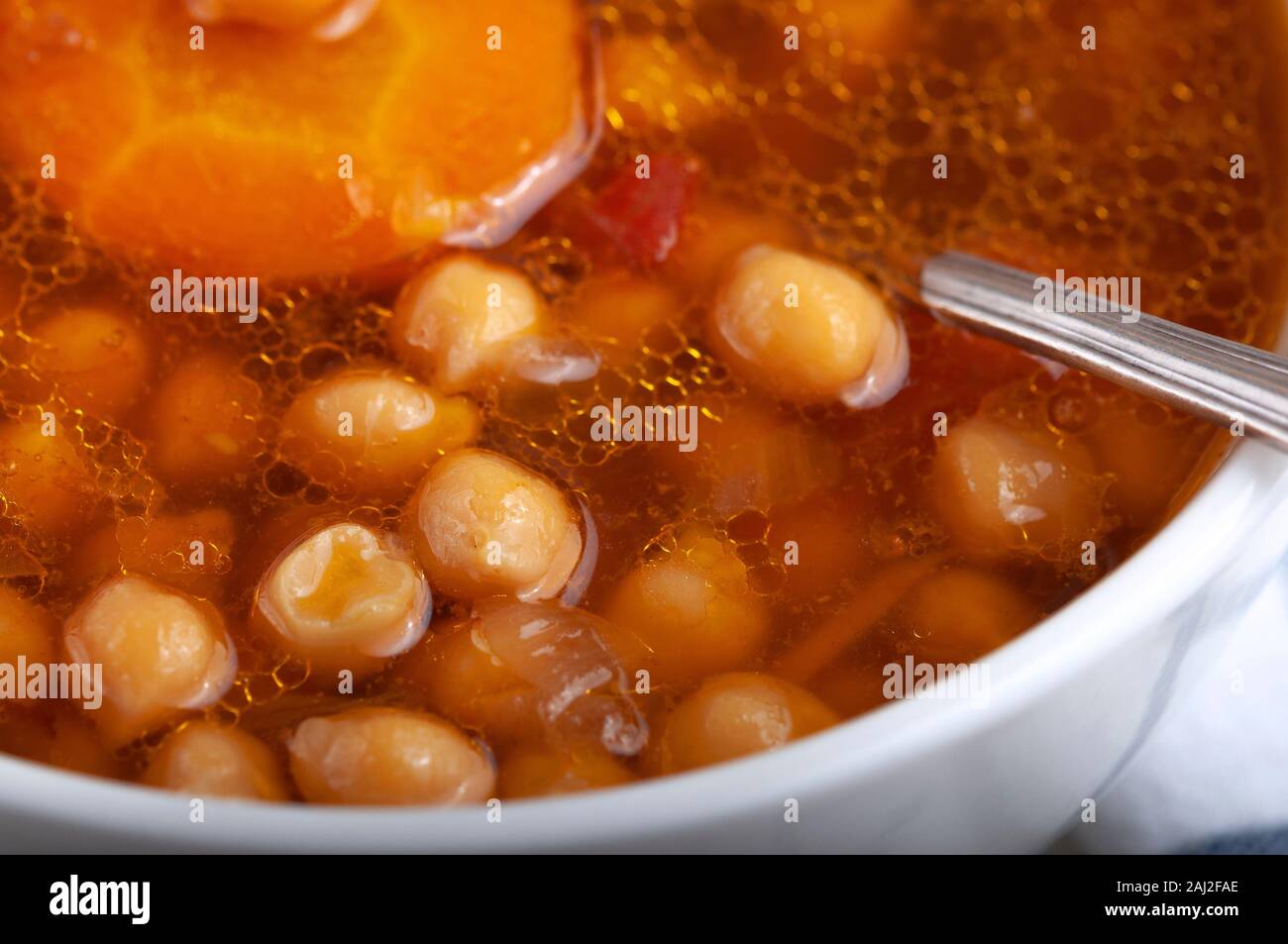 Soupe au poulet, petits pois, tomates et carottes en rondelles. Savoureuse soupe chaude. Banque D'Images