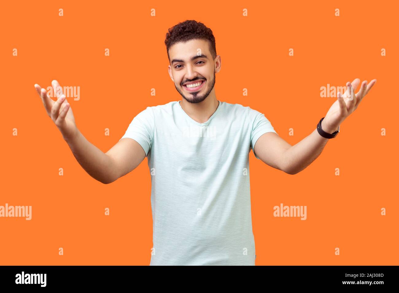 Venez me donner hug. Portrait de l'homme généreux positive brunette avec de barbe blanche occasionnels t-shirt tenant les mains posées et large ouvert à embrasser. je Banque D'Images