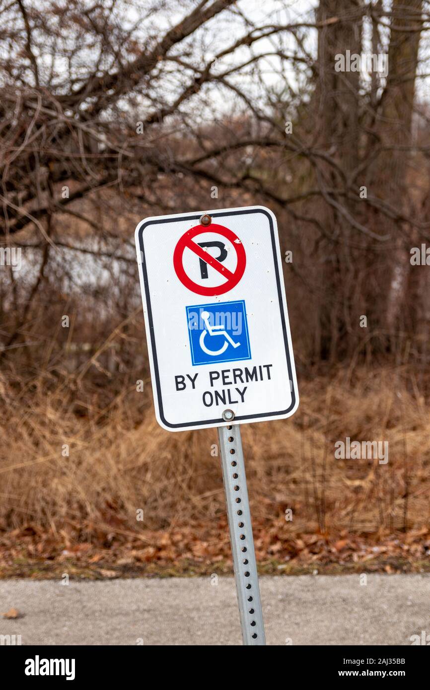 Burlington (Ontario), Canada, 2 janvier 2020 : panneau blanc avec symboles rouge et bleu indiquant un stationnement réservé aux personnes handicapées dans un parc municipal Banque D'Images