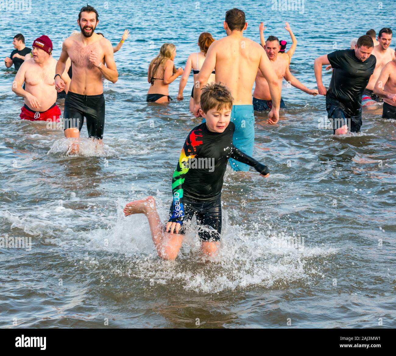 Les gens de la mer pour 2020 Nouvel An Loony Dook ou plonger avec un garçon courir dans l'eau, North Berwick, East Lothian, Scotland, UK Banque D'Images