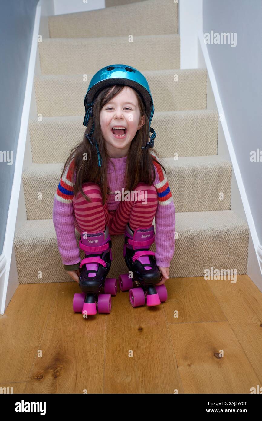 Heureux l'enfant habillé pour rollers à l'intérieur de la maison Banque D'Images