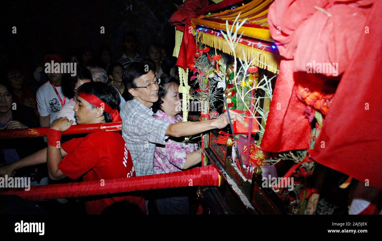 Un homme a mis l'argent dans un chariot décoratif en célébration du nouvel an chinois festival. Banque D'Images