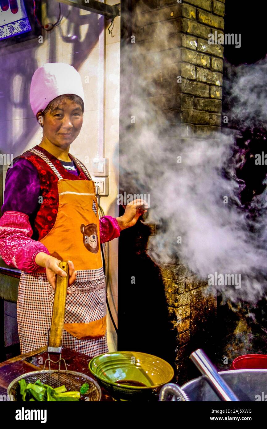 Xi'an, Chine - Avril 2015 : un fournisseur au service de la célèbre spécialité de Xian, plat de nouilles biang biang mian, dans le marché nocturne de la rue musulmane dans la ville de Banque D'Images