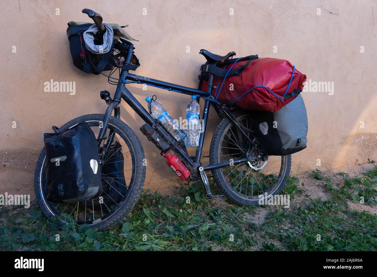 Un vélo de voyage, entièrement chargé, appuyé contre un mur Photo Stock -  Alamy