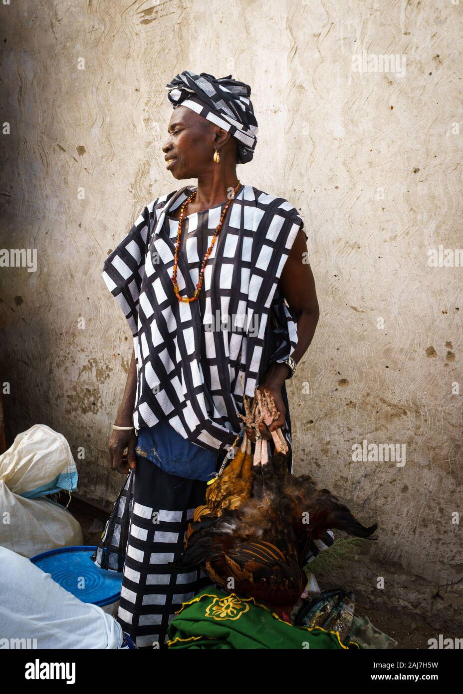 Fière femme africaine en tenue traditionnelle vente de poulets au marché au Sénégal, l'Afrique - Photo : Iris de Reus Banque D'Images