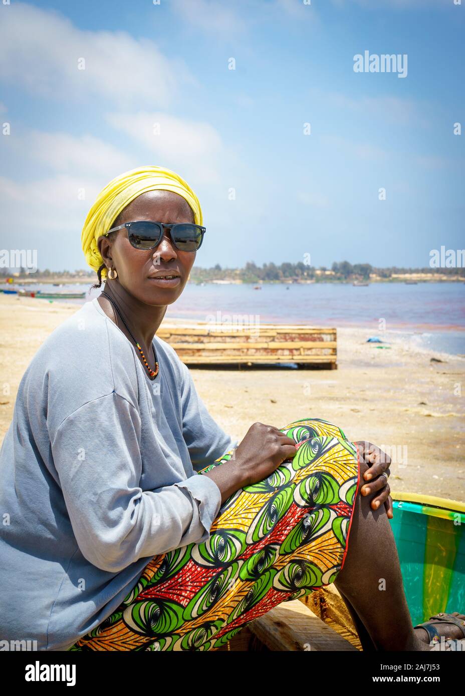 Les jeunes femmes sénégalaises assise sur son bateau en bois portant des lunettes  de soleil sur le lac, au bord du Lac Retba, Sénégal - le 26 avril 2016  Photo Stock - Alamy