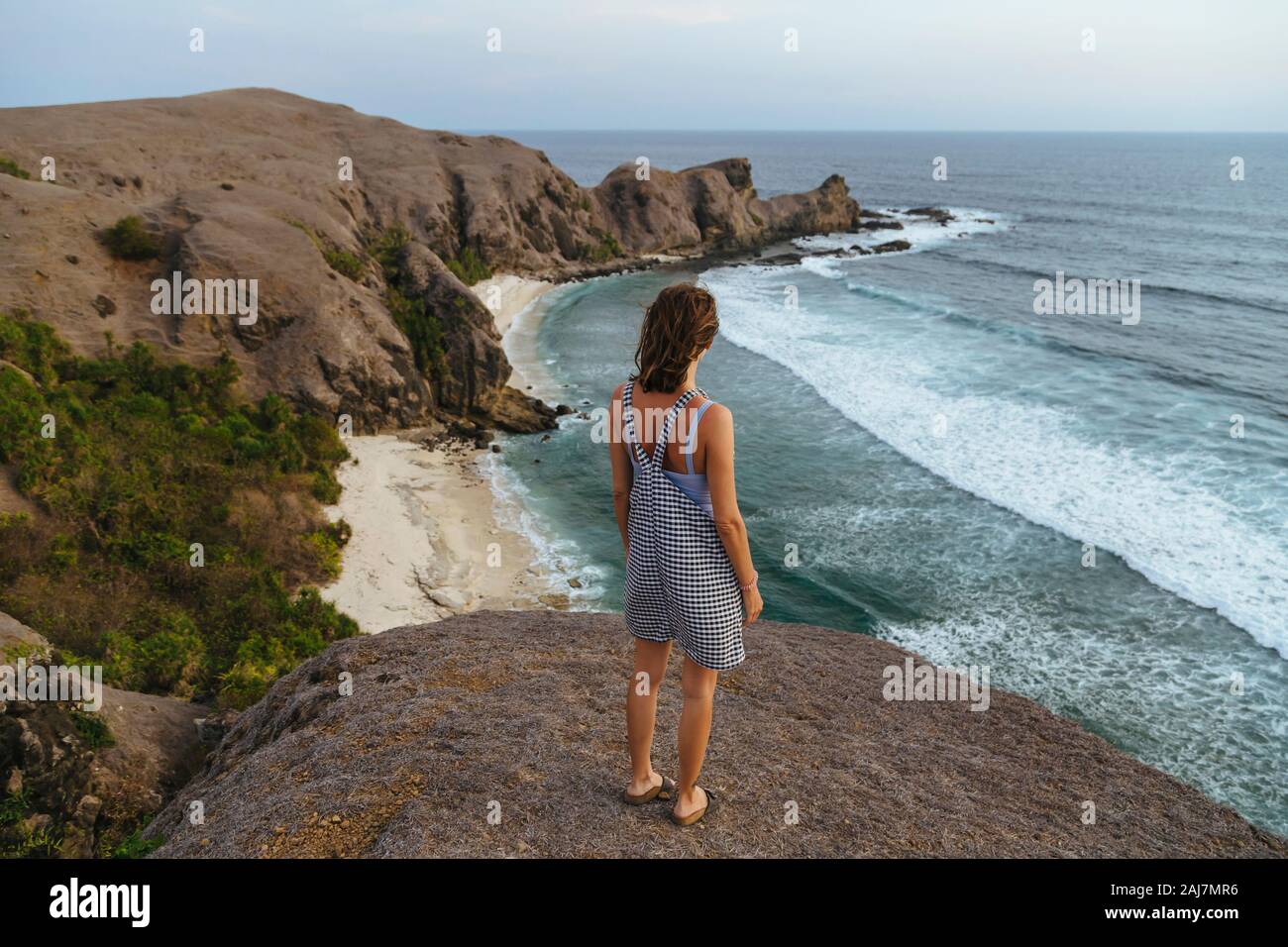 Jeune femme qui séjourne à la colline et regarde la vue Banque D'Images