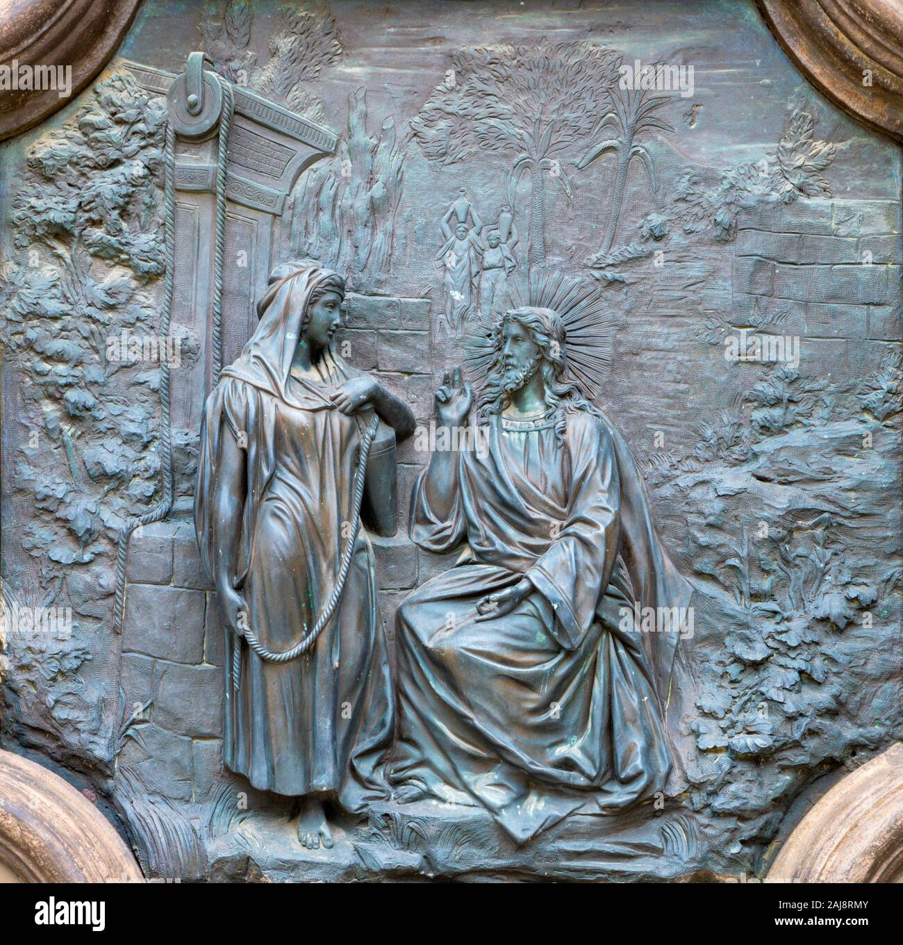 ACIREALE, ITALIE - 11 avril 2018 : allégement de Bronze de Jésus avec la femme samaritaine au puits à partir de la porte de Basilica Collegiata di San Sebastiano. Banque D'Images