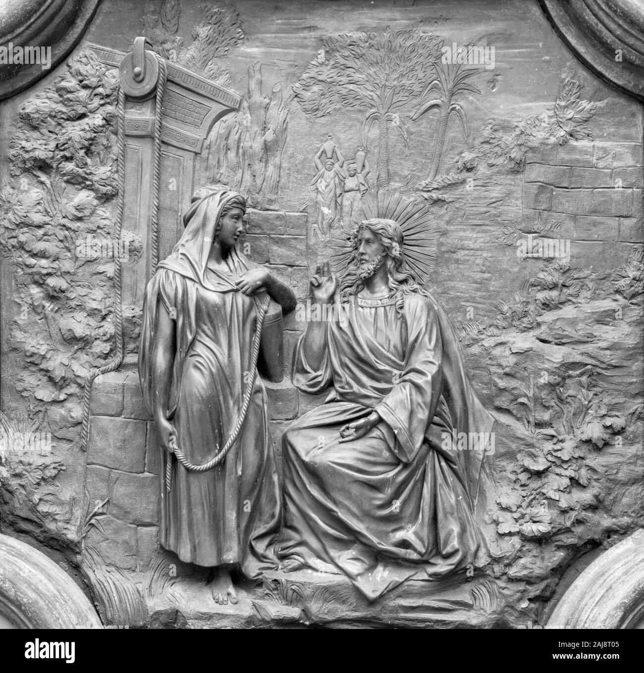 ACIREALE, ITALIE - 11 avril 2018 : allégement de Bronze de Jésus avec la femme samaritaine au puits à partir de la porte de Basilica Collegiata di San Sebastiano. Banque D'Images