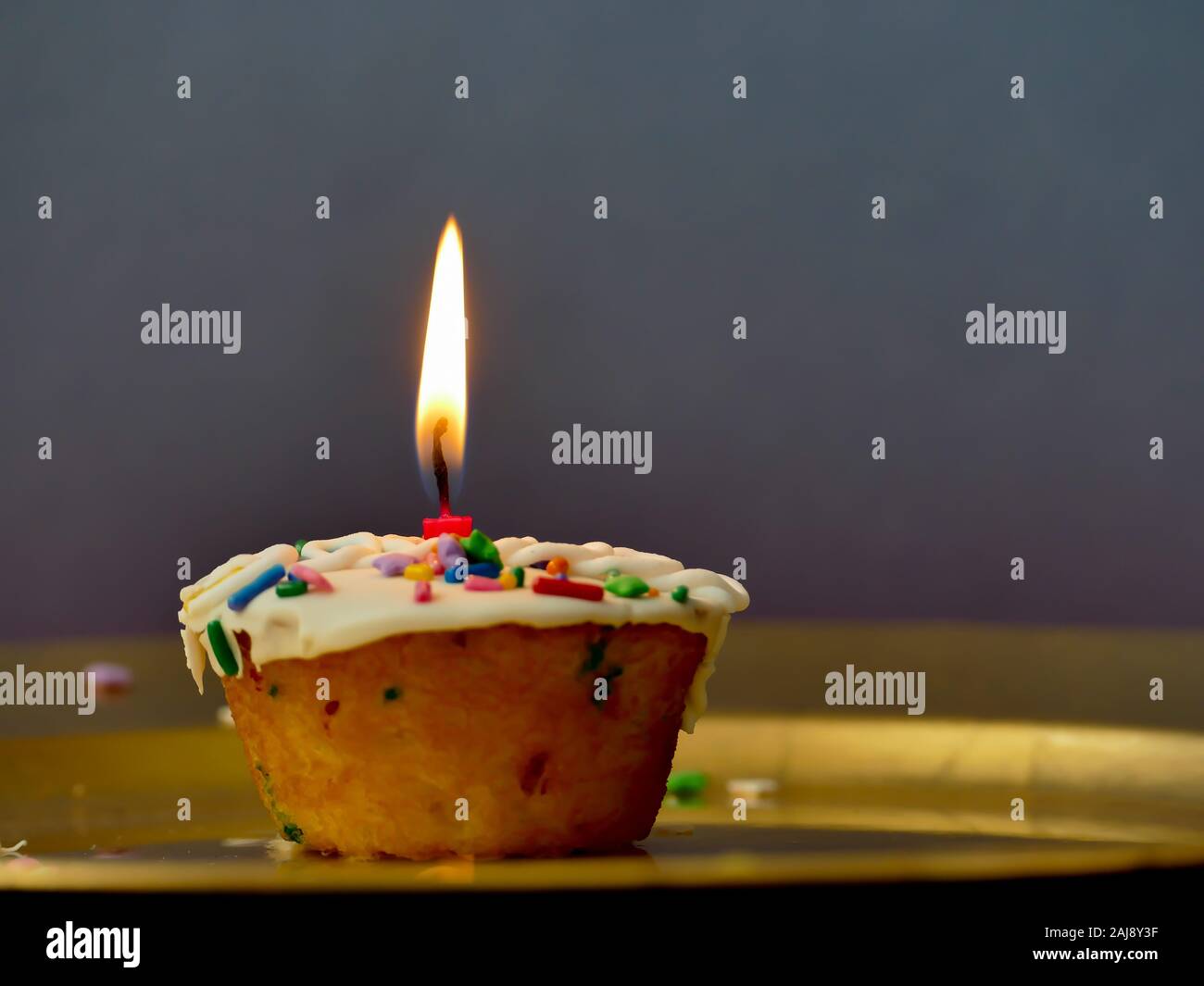 Cup Cake avec une bougie sur fond sombre Banque D'Images