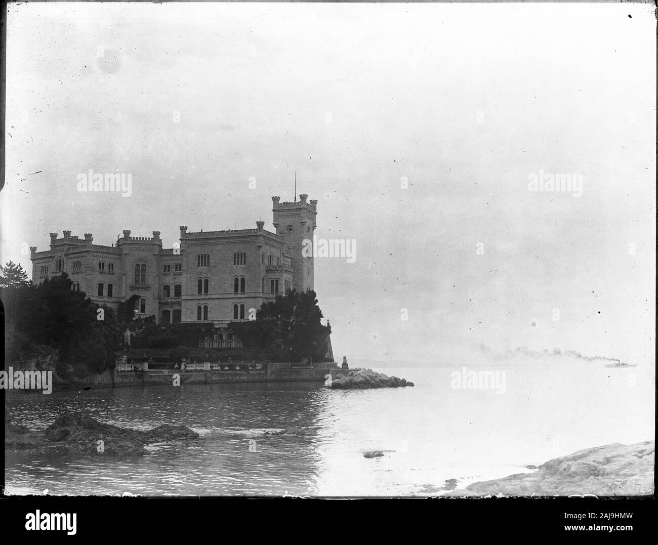 Château de Miramare est un château du xixe siècle dans le Golfe de Trieste, près de Trieste, au nord-est de l'Italie. Il a été construit de 1856 à 1860 pour l'archiduc autrichien Ferdinand Maximilien et son épouse, Charlotte de Belgique, plus tard l'Empereur Maximilien I et de l'Impératrice Carlota du Mexique, fondé sur une conception par Carl Junker. Photographie datée autour de 1910-1920. Un bateau croisière avec un énorme nuage de fumée sur le côté droit. Copier à partir d'une plaque de verre à sec, provenant de l'Herry W. Schaefer collection. Banque D'Images