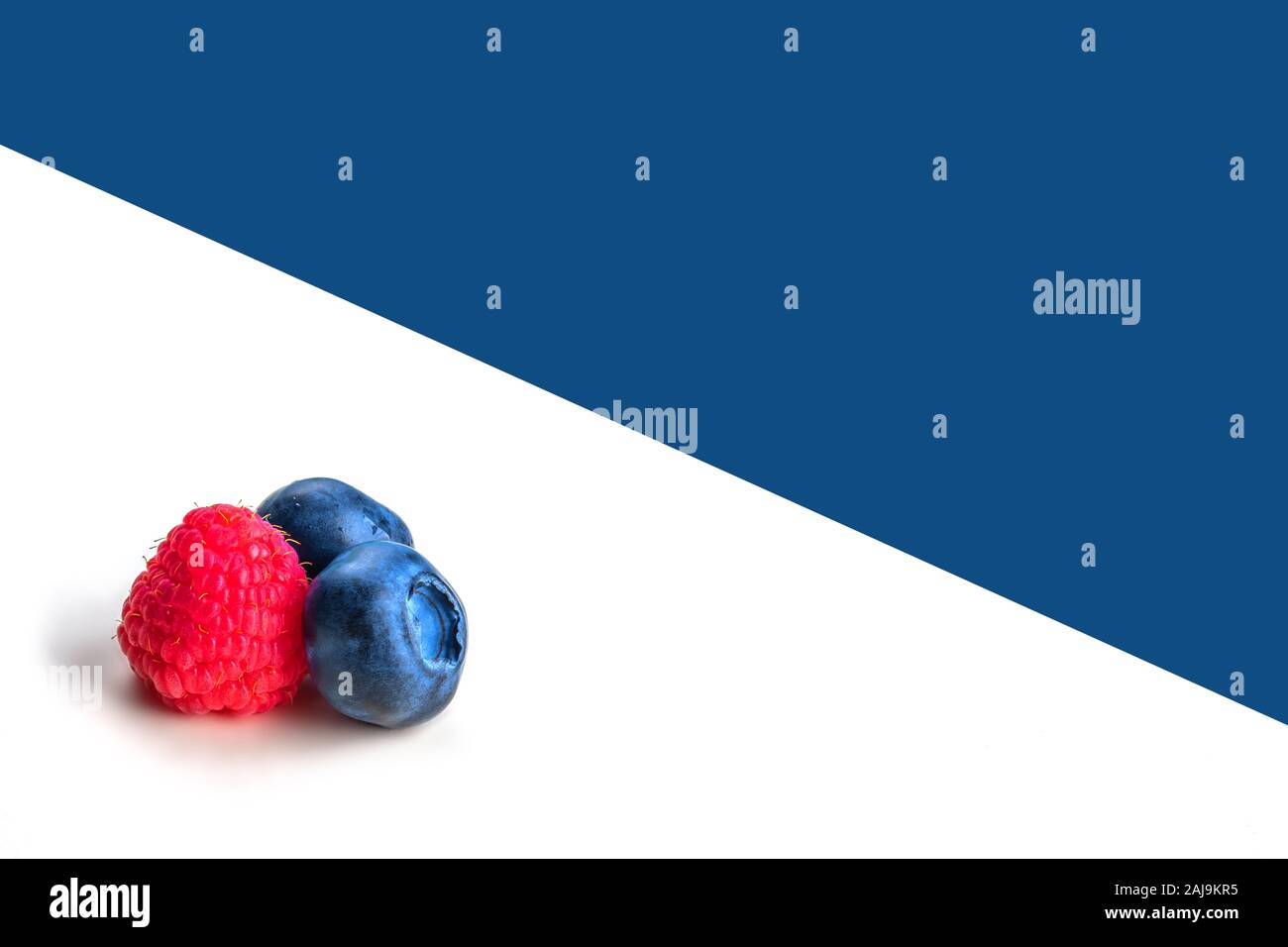 Les bleuets et framboises whiteand sur fond bleu. Close up, vue du dessus, produit de haute résolution. Concept de récolte Banque D'Images