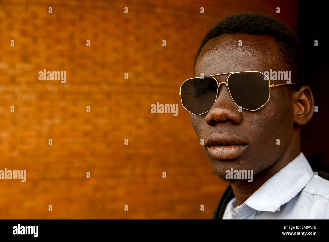 Jeune homme portant des lunettes de soleil à Ouagadougou, Burkina Faso Banque D'Images