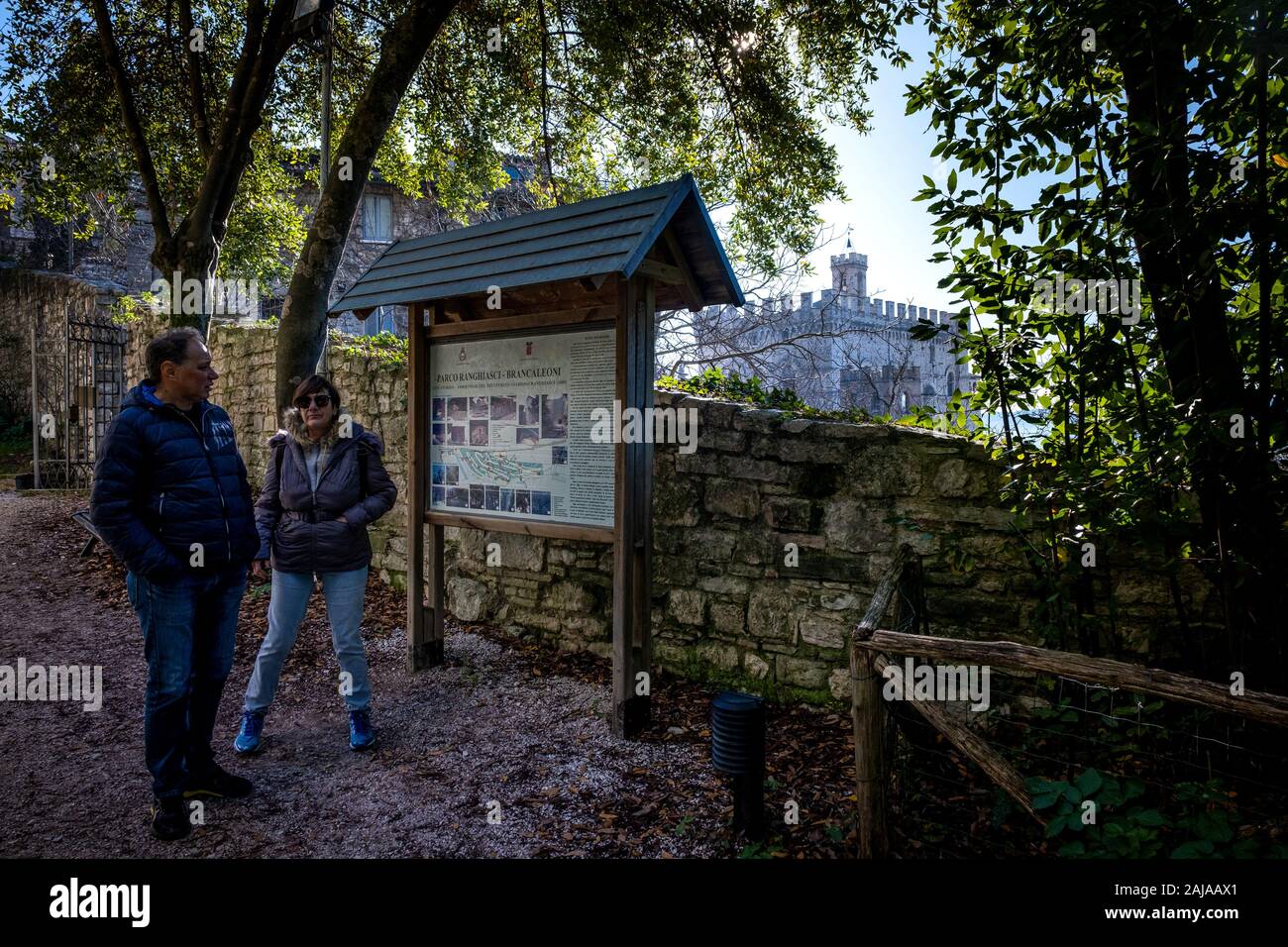 GUBBIO, ITALIE - 01 janvier 2020 : deux touristes inconnu vérifier les signes dans le parc Ranghiasci en hiver, dans l'arrière-plan le palais ducal à Gubbio, Banque D'Images