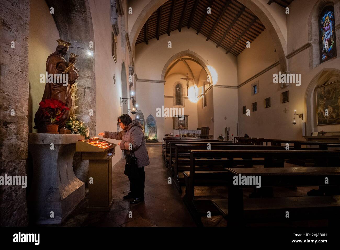 GUBBIO, ITALIE - janvier 01, 2020 : inconnu personne offre un cierge à la Sainte Vierge Marie à l'intérieur de l'église de San Giovanni Battista en Banque D'Images