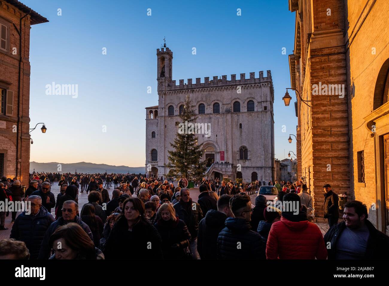 GUBBIO, ITALIE - janvier 01, 2020 : des inconnus dans la Piazza Grande avec le Palazzo dei Consoli à Gubbio, une ville médiévale en Ombrie dans la provinc Banque D'Images